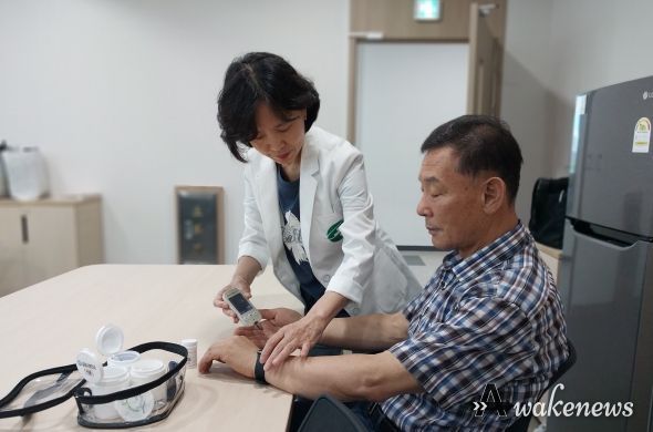 ‘AI·IoT 기반 어르신 건강관리 사업’에 참여 중인 한 어르신이 혈당 체크 후 기기를 통한 결과를 기다리고 있다.