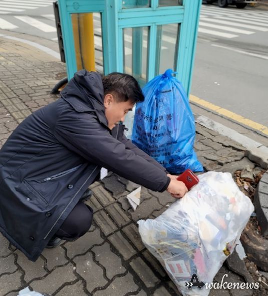 수원시 깨끗한 쓰레기처리 감시원이 무단 배출된 생활폐기물을 살펴보고 있다.