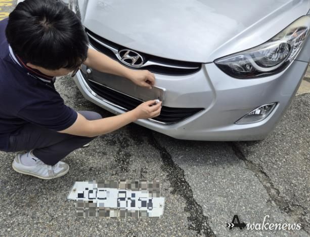 수원시 관계자가 체납차량의 번호판을 영치하고 있다.