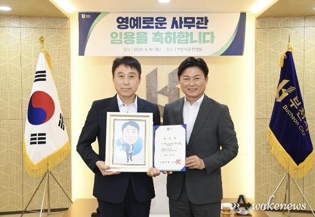 조용익 부천시장과 조국제 일자리정책과장이 5급 승진 임용장과 캐리커처를 들고 기념촬영을 하고 있다