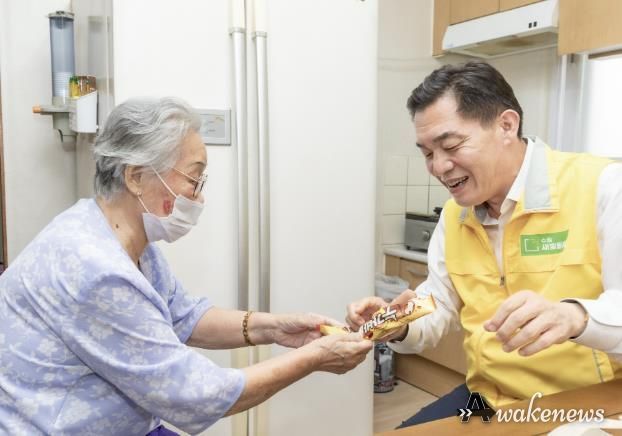 강OO 할머니가 이재준 시장에게 아이스크림을 건네고 있다.