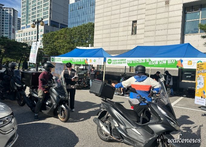 배달노동자 이륜차를 점검하고 있다.