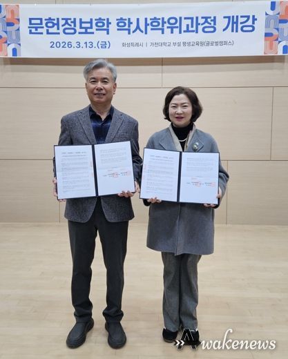 윤미영 도서관정책과장과 가천대 평생교육원 이재원 주임교수가 협약서를 들고 기념촬영을 하고 있다